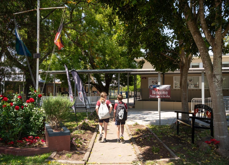 2 students walking into school gate