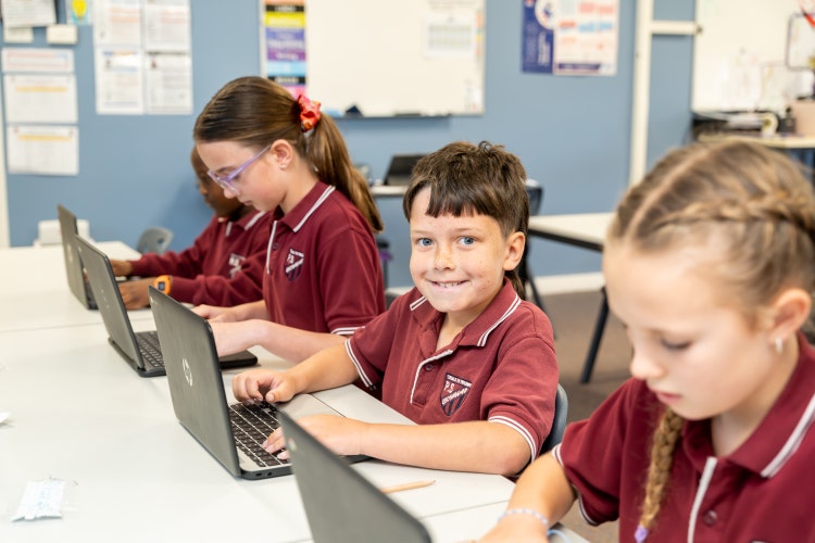 Students engaging in digital learning and smiling