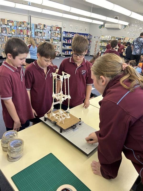 Picture of students engaging in STEM activitie with High school student