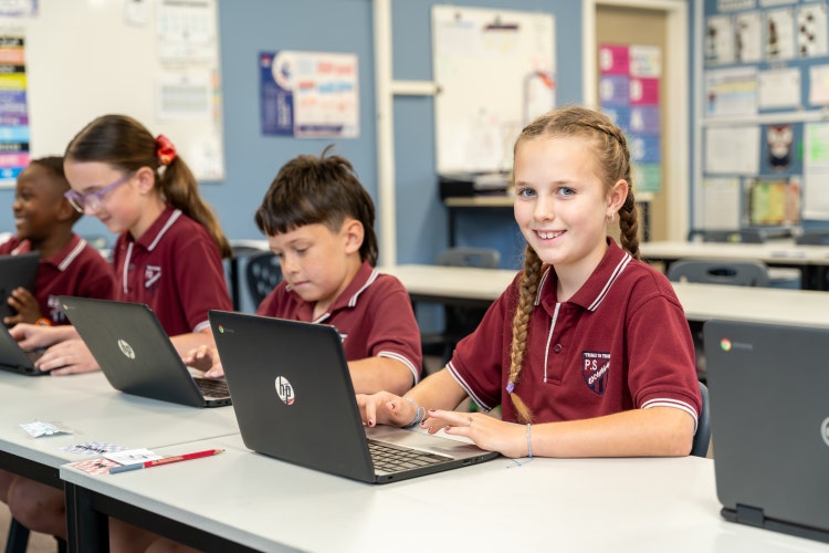 pciture of students engaging in digital learning and smiling