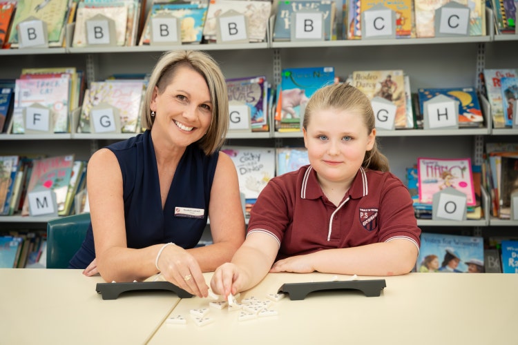 Picture of Principal and student reading a book smiling