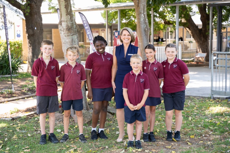 Prinicpal standing with students smiling